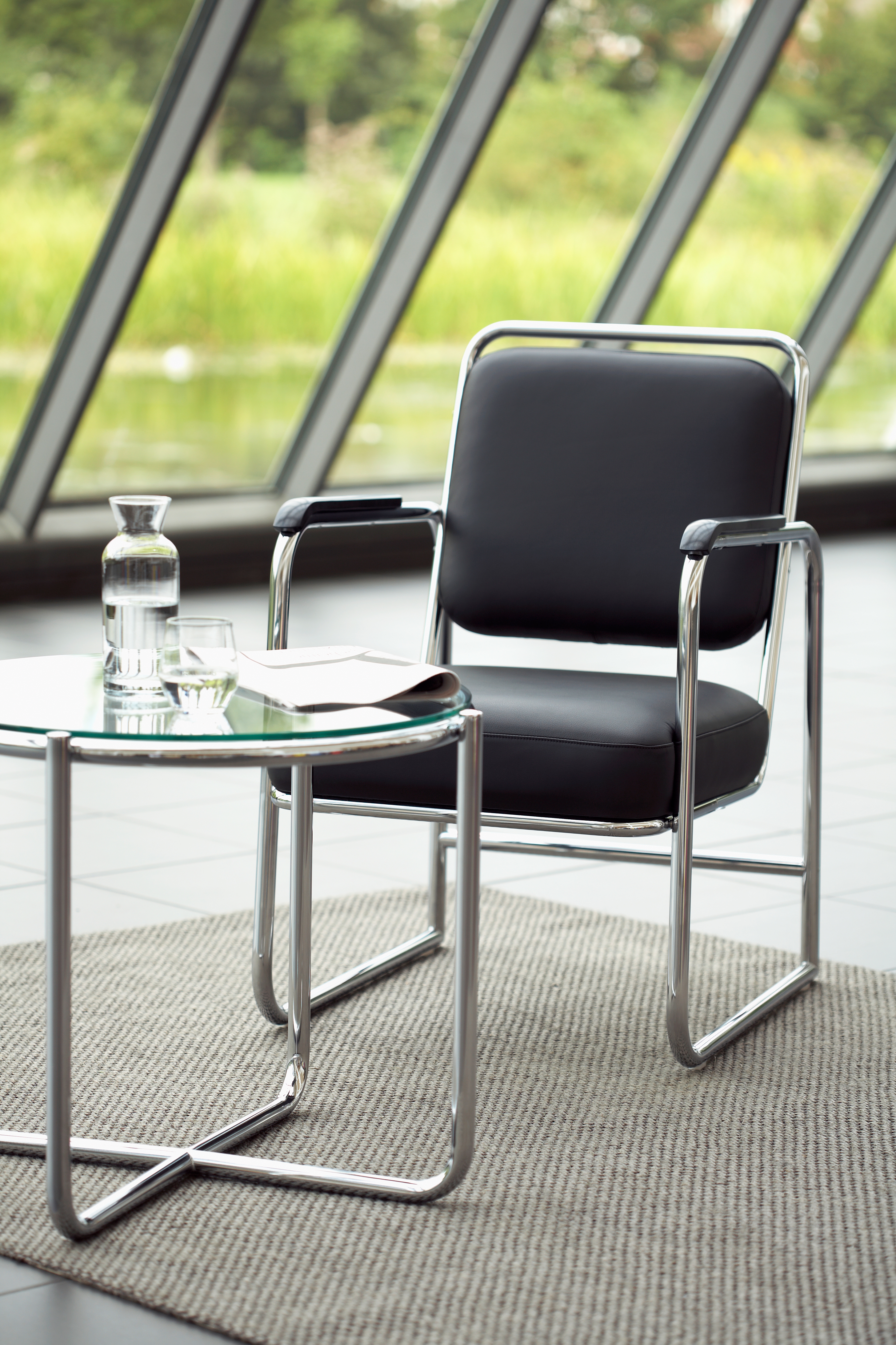 Bauhaus Beistelltisch Dessau und Freischwinger Berlin aus gebogenem Stahlrohr mit Glasplatte und Freischwinger Berlin mit Lederbezug 