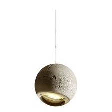 An einem dünnen Drahtseil hängt eine feine Betonkugel mit einer Glaslinse - die Pendelleuchte TRABANT 1.  Sie erinnert in Form und Gestalt an den Mond, unseren Erdtrabanten. Für ihre Einzigartigkeit erhielt die Hängeleuchte aus Beton mehrere Auszeichnungen.   Kugel-Pendelleuchte TRABANT 1, 180 mm, verstellbar