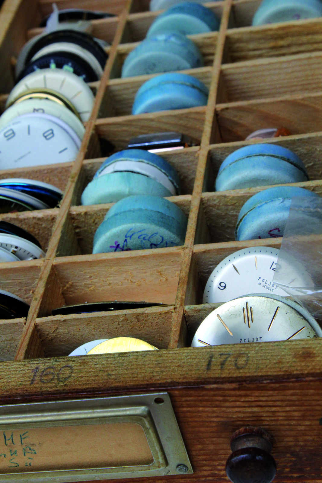 In einer Schublade findet sich eine Sammlung von historischen Ziffernblättern